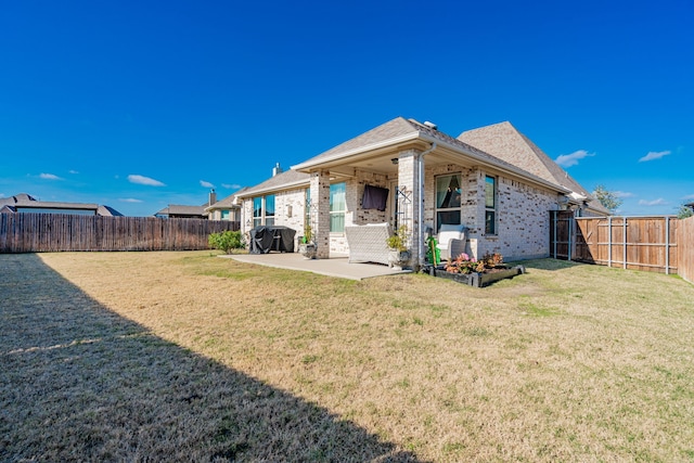 back of house with a yard and a patio