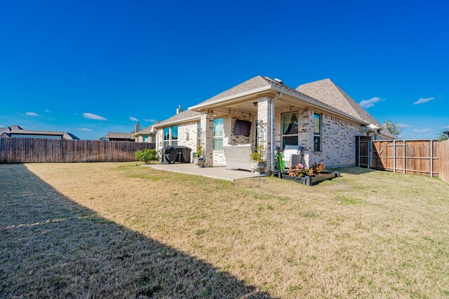 back of house featuring a yard and a patio