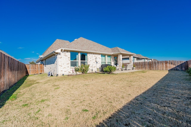 back of property with a lawn and a patio area