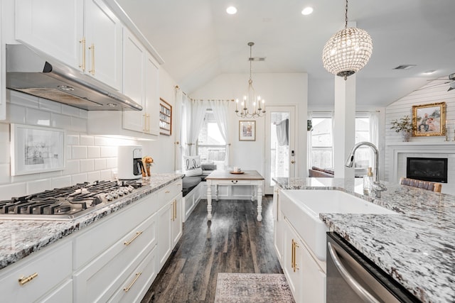 kitchen with white cabinetry, decorative light fixtures, stainless steel appliances, and lofted ceiling