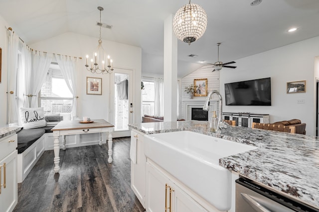 kitchen featuring dishwasher, vaulted ceiling, hanging light fixtures, and white cabinets