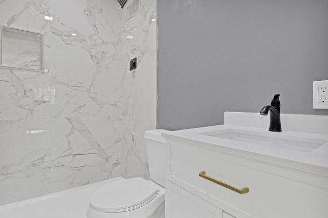 bathroom featuring tiled shower, vanity, and toilet