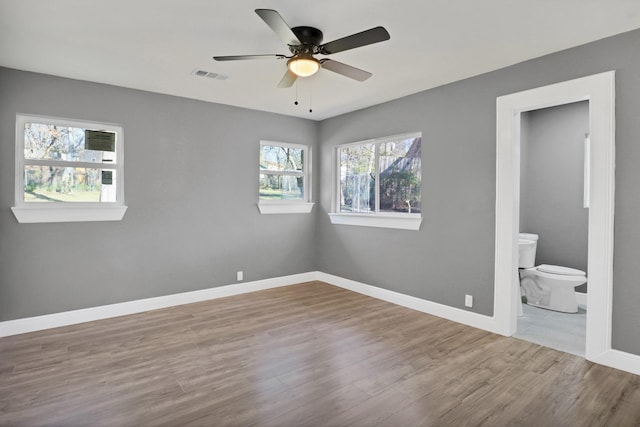 unfurnished bedroom with connected bathroom, light hardwood / wood-style flooring, and ceiling fan