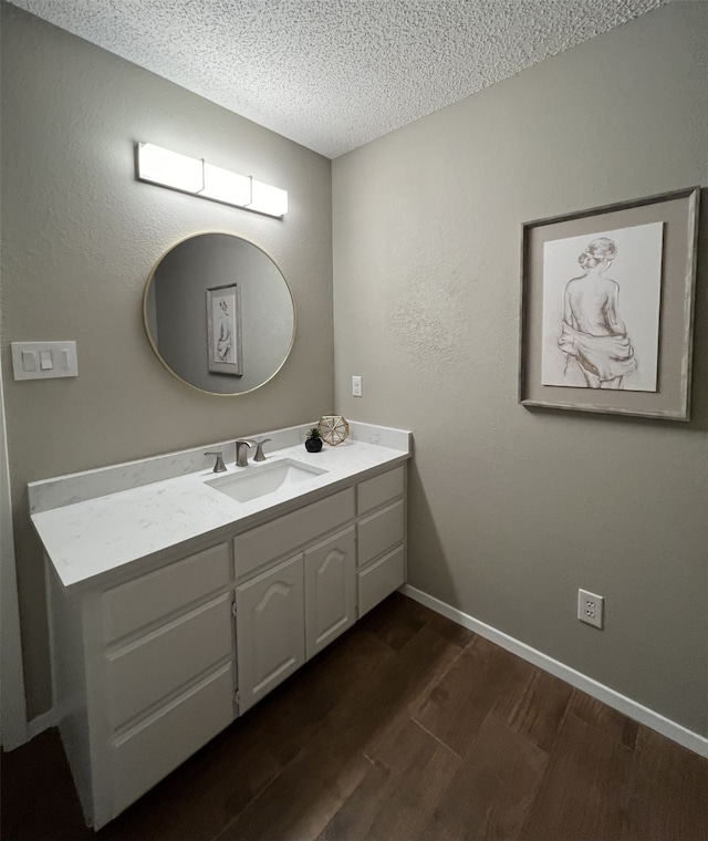 bathroom featuring hardwood / wood-style flooring, vanity, and a textured ceiling