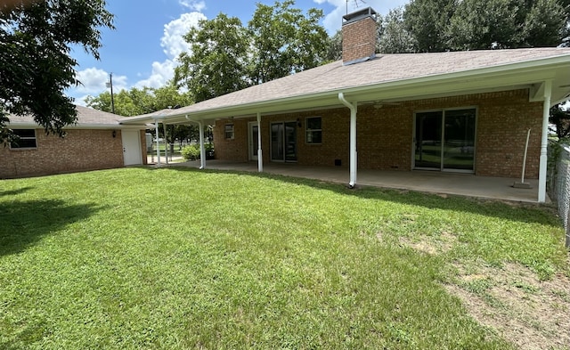 rear view of house featuring a patio area and a lawn