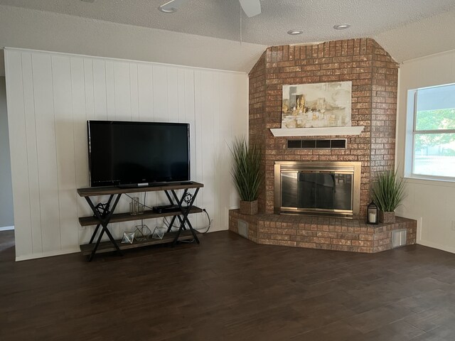 living room with a fireplace, a textured ceiling, dark wood-type flooring, and lofted ceiling