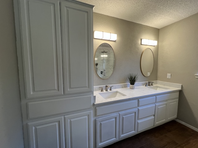 bathroom featuring vanity, hardwood / wood-style flooring, and a textured ceiling