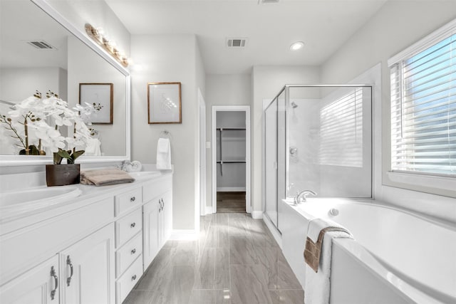 bathroom with plenty of natural light, shower with separate bathtub, and vanity