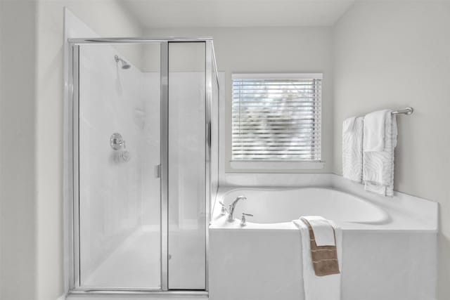 bathroom featuring shower with separate bathtub