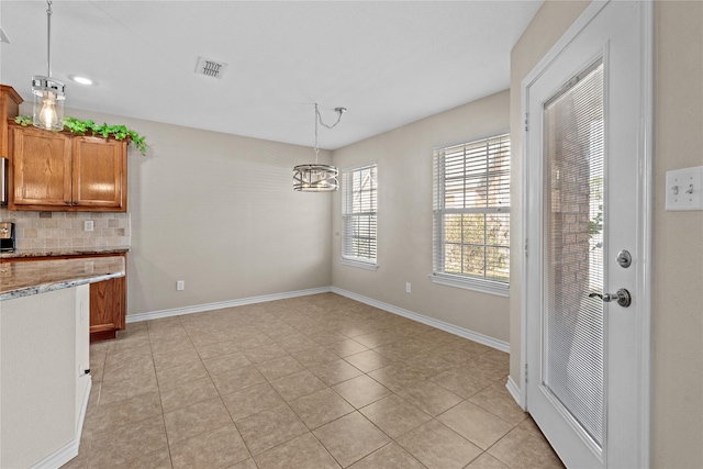 kitchen with tasteful backsplash, light tile patterned flooring, decorative light fixtures, and a notable chandelier