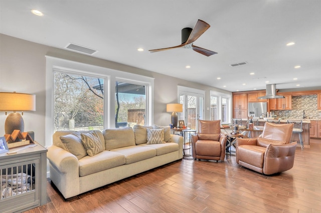 living room featuring light hardwood / wood-style floors and ceiling fan