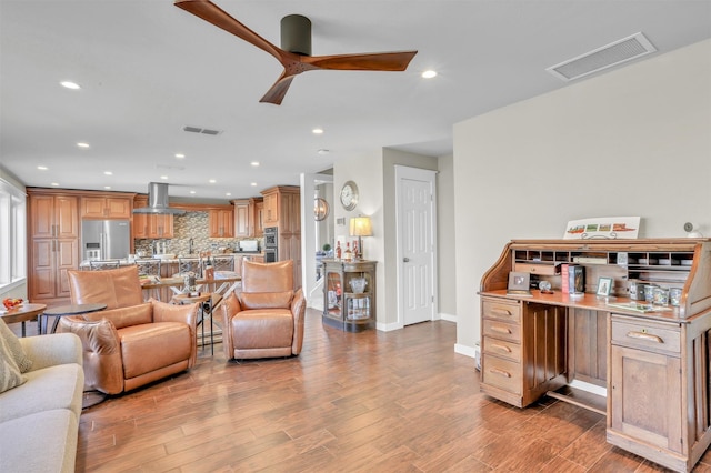 living room with ceiling fan and light wood-type flooring