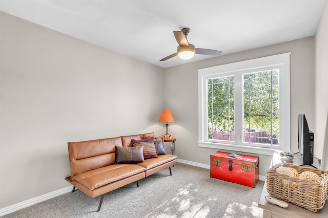 living area featuring light carpet and ceiling fan