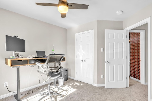 carpeted home office featuring ceiling fan