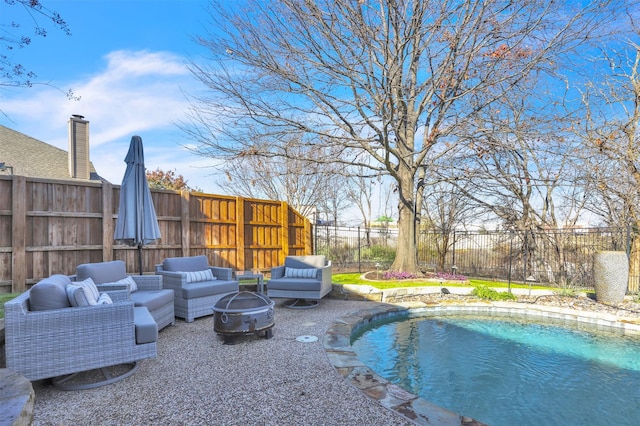 view of pool featuring an outdoor living space with a fire pit