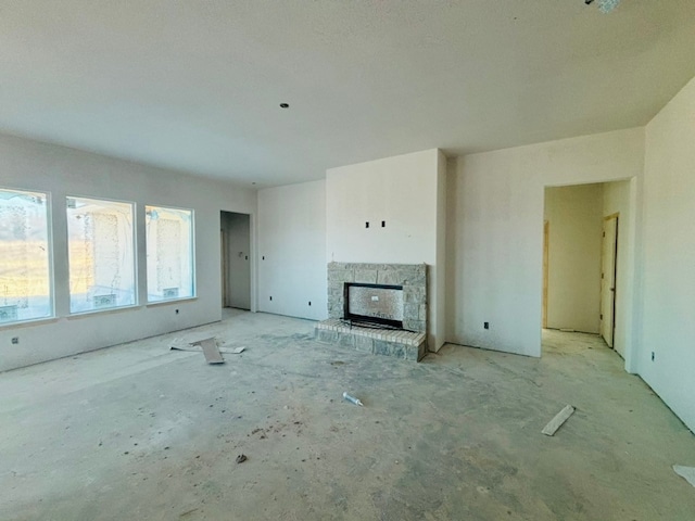 unfurnished living room featuring a stone fireplace