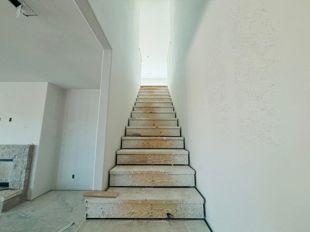 stairs with a stone fireplace