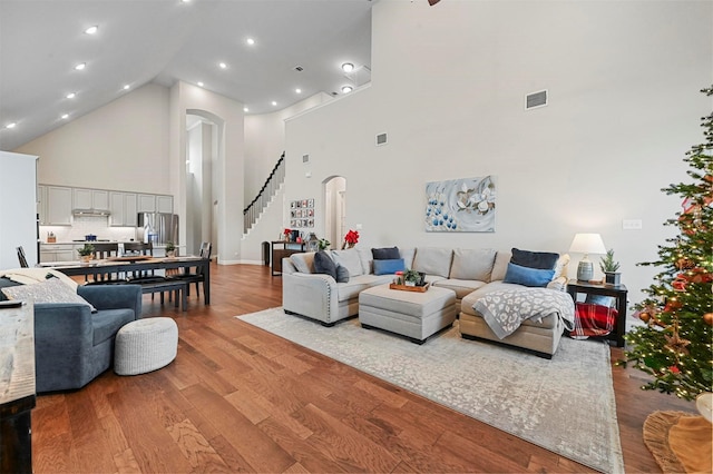 living room with light hardwood / wood-style floors and high vaulted ceiling