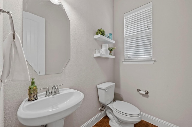 bathroom with hardwood / wood-style flooring, toilet, and sink