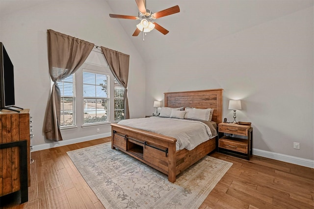 bedroom featuring light hardwood / wood-style floors, high vaulted ceiling, and ceiling fan