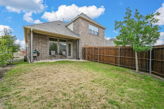 back of property with a yard and a patio area