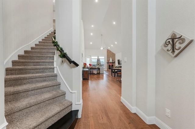 stairway with hardwood / wood-style flooring and ceiling fan