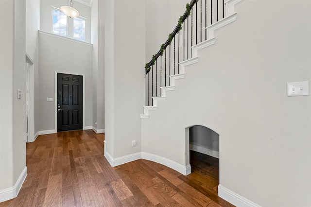 entryway featuring a towering ceiling and hardwood / wood-style flooring