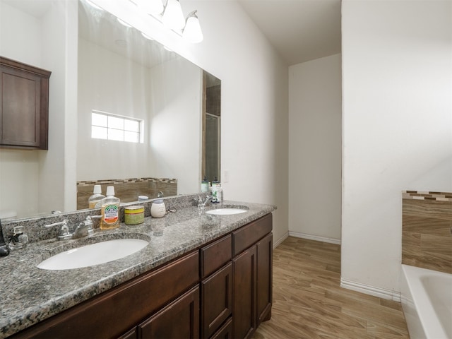 bathroom with a bathtub, hardwood / wood-style floors, and vanity