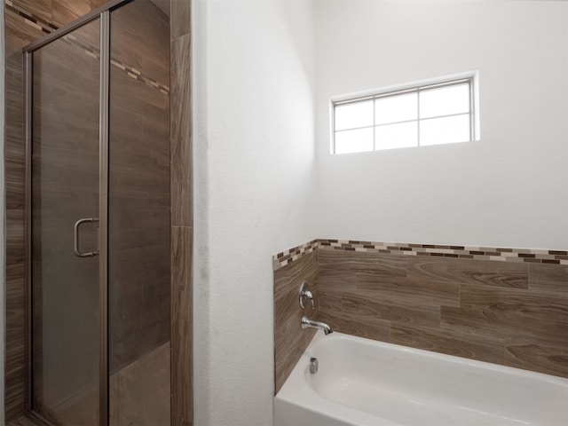 bathroom featuring separate shower and tub