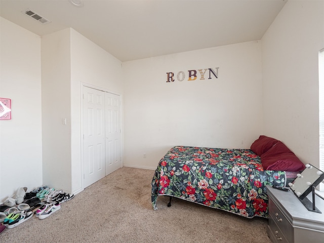 bedroom with light colored carpet and a closet