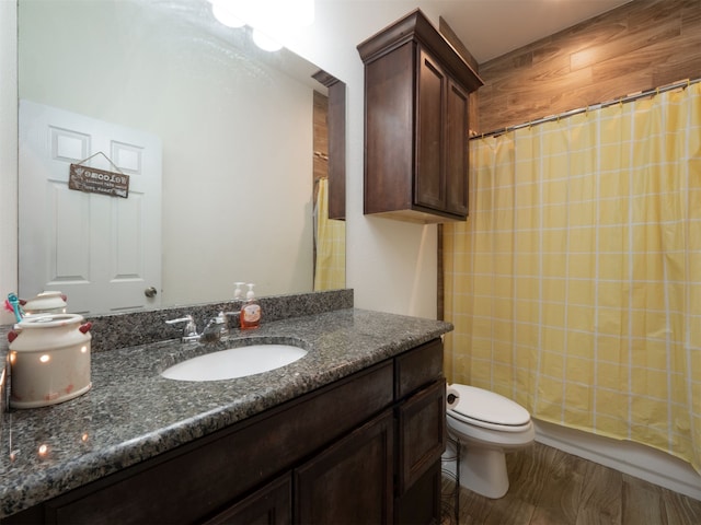 bathroom featuring hardwood / wood-style floors, vanity, toilet, and walk in shower