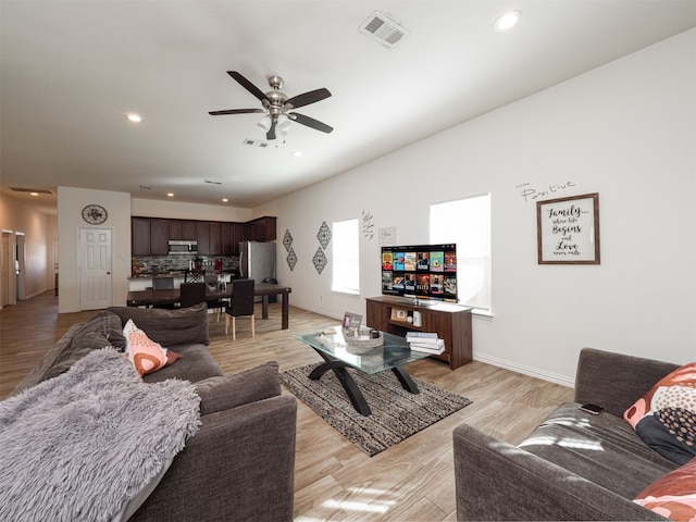 living room featuring light hardwood / wood-style floors and ceiling fan