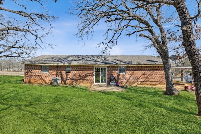 rear view of house featuring brick siding and a lawn