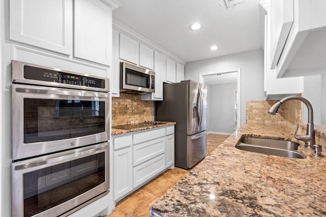 kitchen featuring white cabinets, sink, appliances with stainless steel finishes, and tasteful backsplash