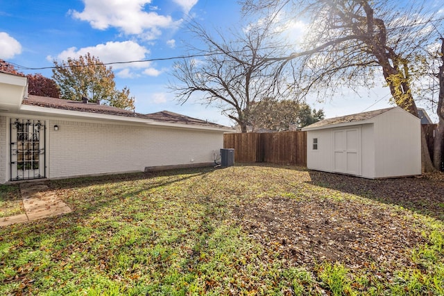 view of yard featuring central AC unit and a shed