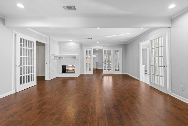 unfurnished living room with dark hardwood / wood-style flooring, french doors, a fireplace, and ornamental molding