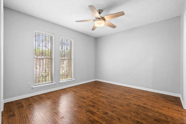 spare room featuring plenty of natural light, dark hardwood / wood-style flooring, and a textured ceiling