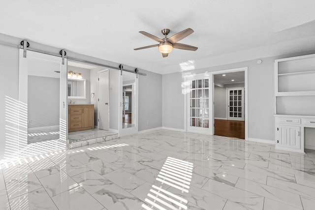 unfurnished living room featuring french doors, ceiling fan, a barn door, built in features, and a textured ceiling