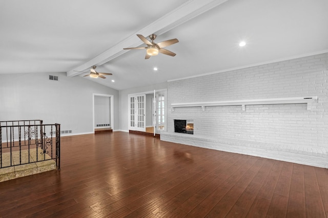 unfurnished living room with ceiling fan, vaulted ceiling with beams, dark hardwood / wood-style flooring, brick wall, and a fireplace