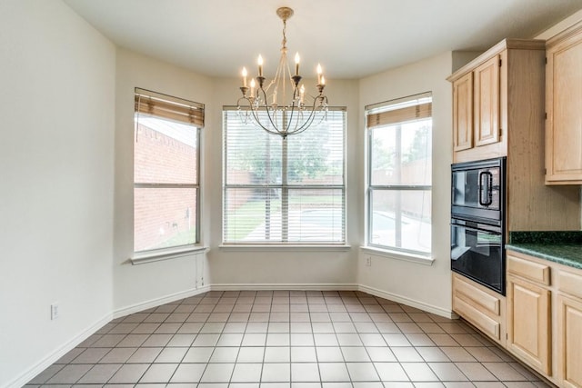 kitchen with light brown cabinets, decorative light fixtures, a notable chandelier, and black appliances