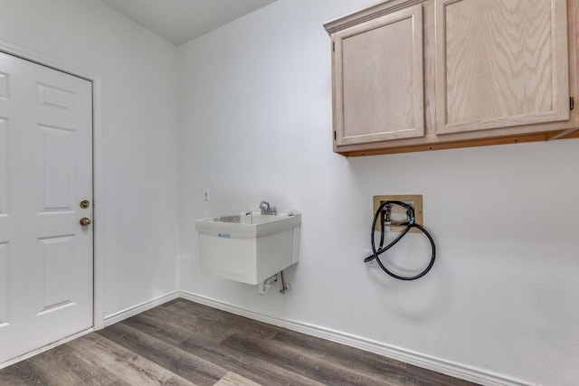 washroom with cabinets, dark hardwood / wood-style flooring, sink, and hookup for a washing machine