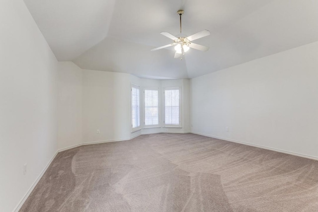 spare room with ceiling fan, lofted ceiling, and light carpet