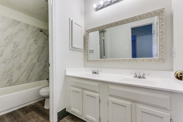 full bathroom with hardwood / wood-style flooring, tiled shower / bath combo, toilet, and vanity