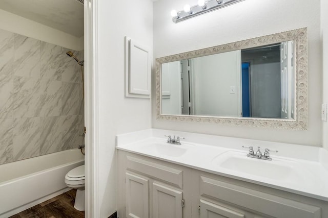 full bathroom with vanity, toilet, wood-type flooring, and tiled shower / bath