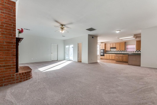 unfurnished living room featuring ceiling fan and light colored carpet