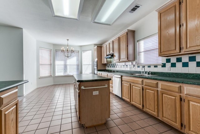 kitchen featuring dishwasher, a center island, backsplash, sink, and a notable chandelier