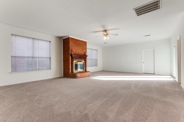 unfurnished living room with ceiling fan, light colored carpet, and a brick fireplace