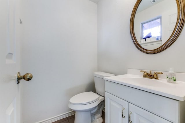 bathroom with toilet, vanity, and tile patterned floors