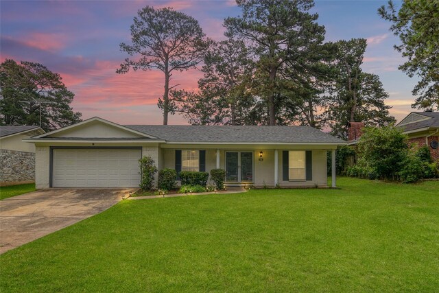 ranch-style house featuring a porch, a garage, and a front lawn