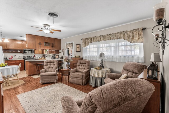 living room featuring light hardwood / wood-style flooring and ceiling fan